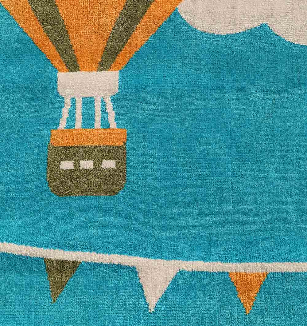 The RAMSHA HOME Modern Kids Area Rug - KD 012 (120x180 cm) features a vibrant hot air balloon, white clouds, and blue background with orange, white, and blue pennant flags—perfect for any kids playroom.