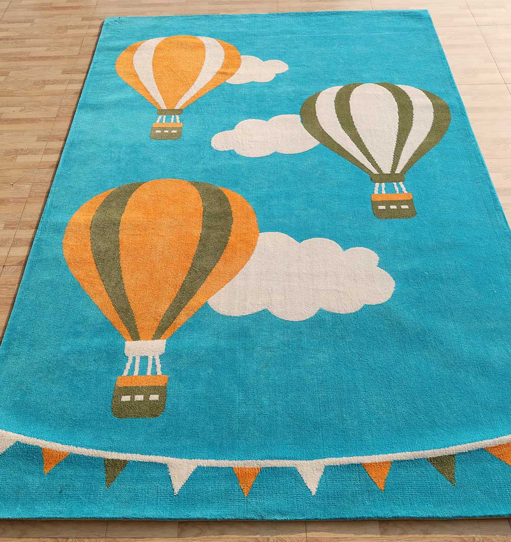 The RAMSHA HOME Modern Kids Area Rug - KD 012 (120x180 cm) features a sky blue design with orange and green hot air balloons, white clouds, and a row of orange, green, and white triangular flags along the bottom edge.