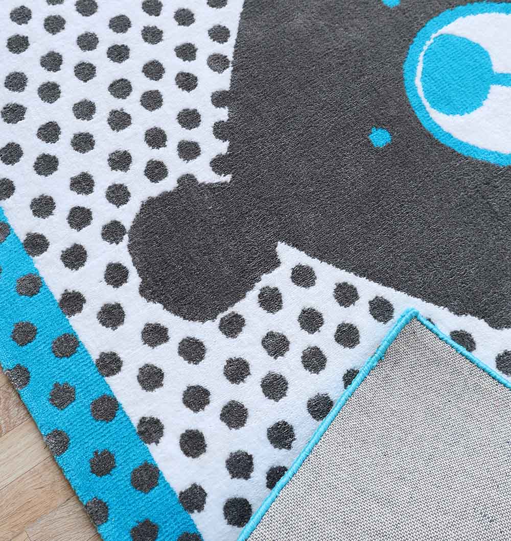 A close-up of the RAMSHA HOME Kids Polka Dot Grey & White Rug with Blue Border – KD 013 (120x180 cm), showing a soft rectangular design with a gray bear, white polka-dotted background, blue border, and non-slip backing—ideal for kids' rooms.