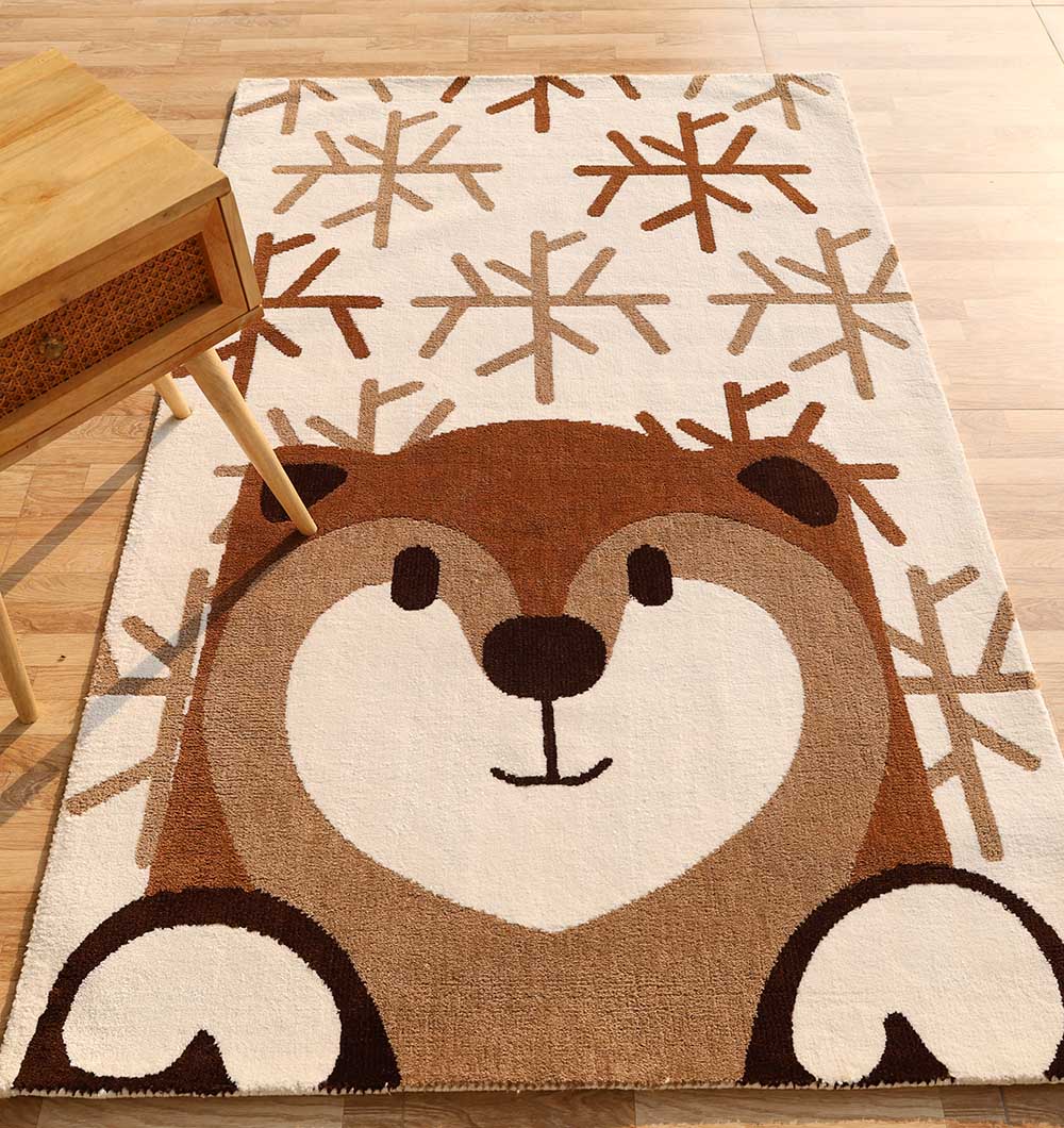 The RAMSHA HOME Kids Bear Face Beige & Brown Rug – KD 014 features a cute cartoon bear face and paws with abstract snowflakes on cream, made of soft polyester, shown under a wooden table in the top left corner.