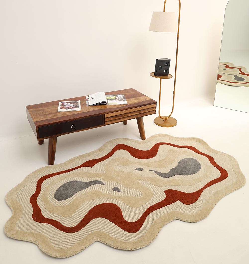 The RAMSHA HOME Amoeba Shaped Multi Color Rug KD 016 (130x200 cm) features beige, brown, red, and gray patterns. Shown on a white floor beside a wooden coffee table, standing lamp, and mirror reflecting its contemporary design.