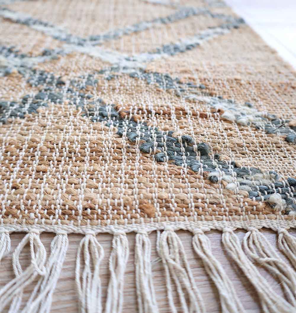 Close-up of the RAMSHA HOME Fringes Jute & Cotton Kilim Flatweave Carpet (KLM 002, 170x240cm), featuring a geometric gray and white pattern and knotted fringe detailing along the edge.
