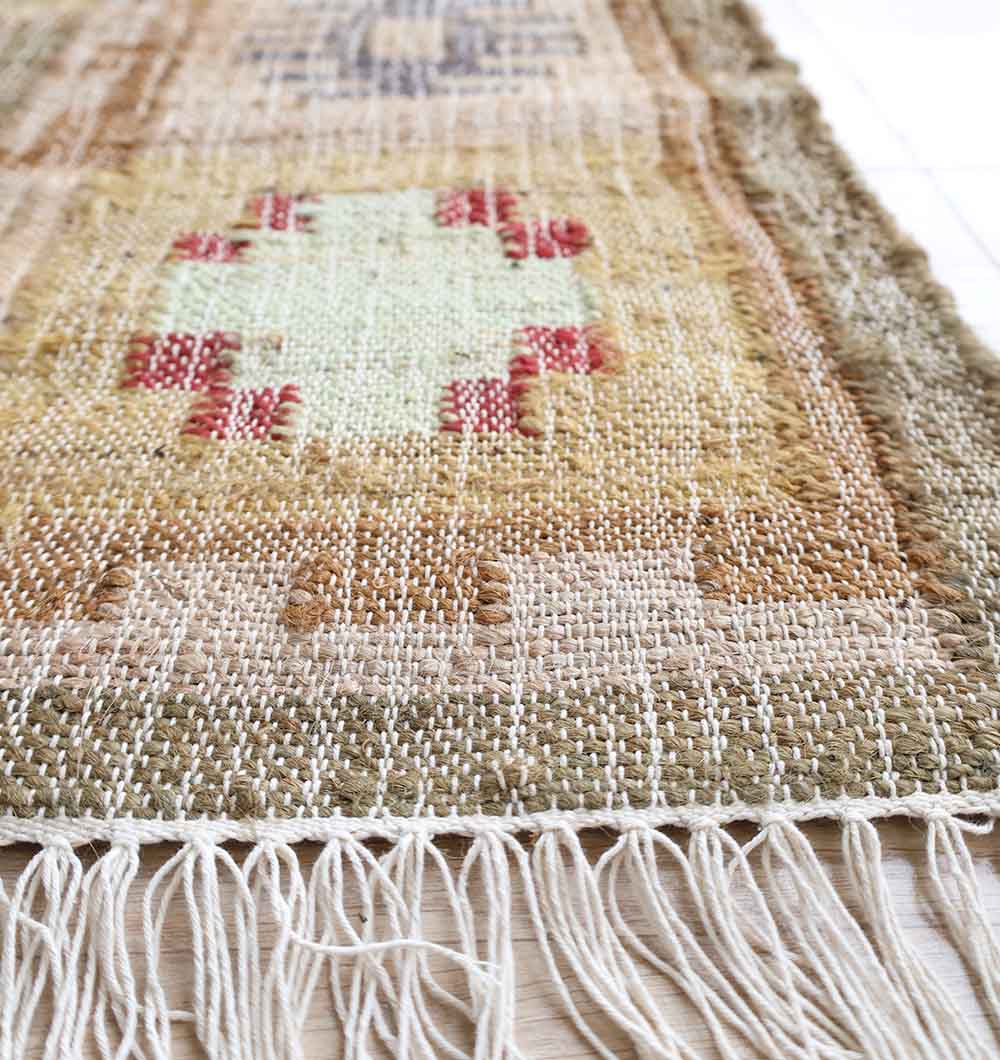 Close-up of the fringed edge and textured weave of the RAMSHA HOME Symmetrical Bordered Traditional Kilim Rug - KLM 007 (170x240cm), featuring earthy beige, light brown, olive hues with bold red and cream geometric patterns.