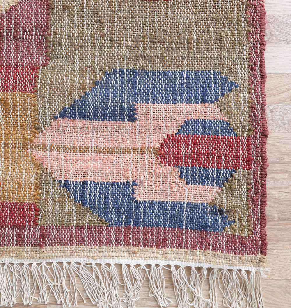 A close-up shows the RAMSHA HOME Handwoven Diamond Patterned Kilim Rug (KLM-010, 170x240cm) with blue, pink, red, and olive green geometric designs and a short fringe edge, displayed on a light wooden floor.