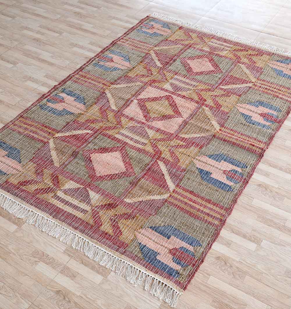 The RAMSHA HOME Handwoven Diamond Patterned Kilim Rug (KLM-010, 170x240cm) features geometric diamond designs in pink, red, yellow, and blue with fringed edges, shown here on a light wooden floor.