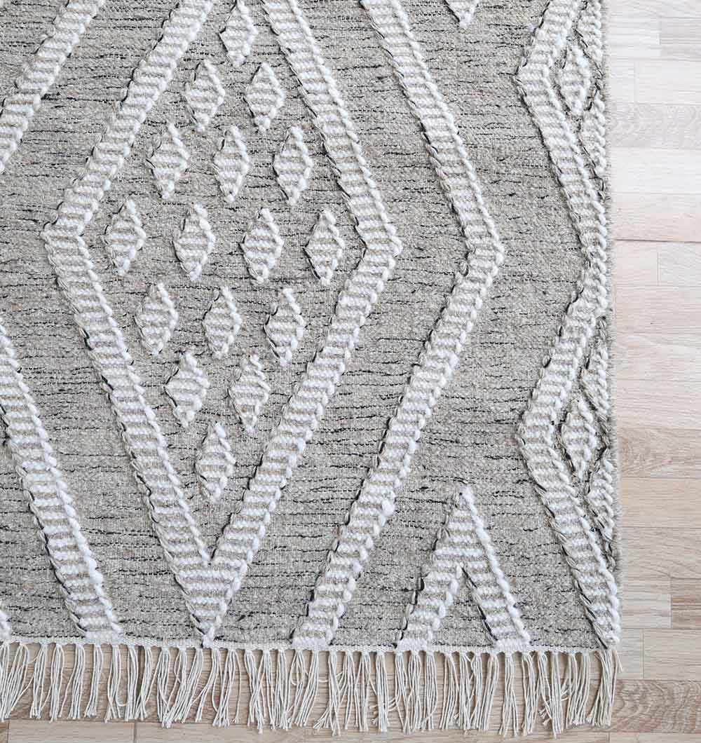 The RAMSHA HOME Handwoven Diamond Patterned Grey Kilim Rug (KLM-017, 170x240cm) features a textured geometric design with fringe on one edge, shown here on a light wood floor.
