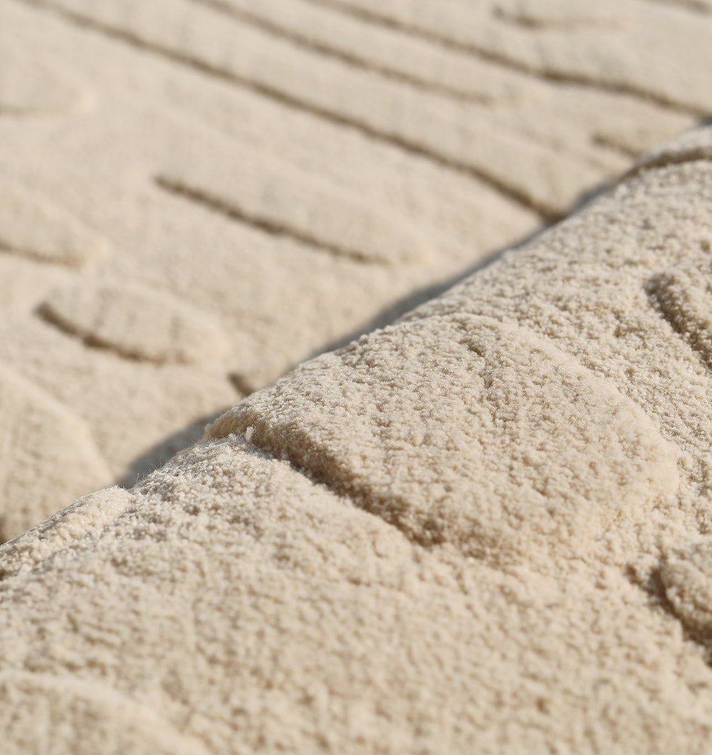 Close-up view of the RAMSHA HOME Modern Beige Textured Area Rug (LKH-026), featuring an abstract wavy pattern with raised lines and shapes that create a subtle, tactile design in soft neutral tones.