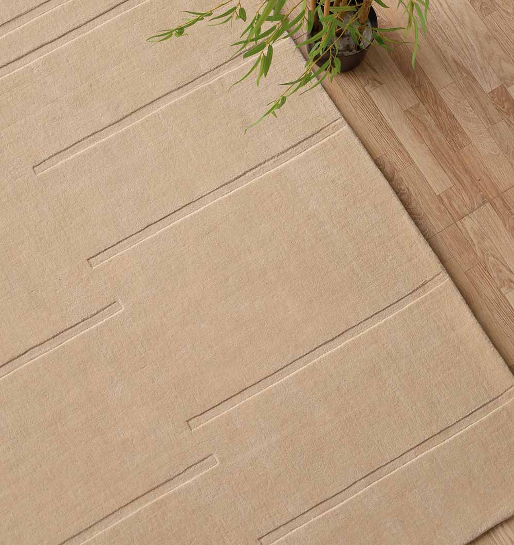 The RAMSHA HOME Rectangle Handmade Decorative Beige Color 250x350 cm Area Rug (LKH-031) adds minimalist charm to the space, placed on a light wooden floor near a green leafy plant in a brown pot.