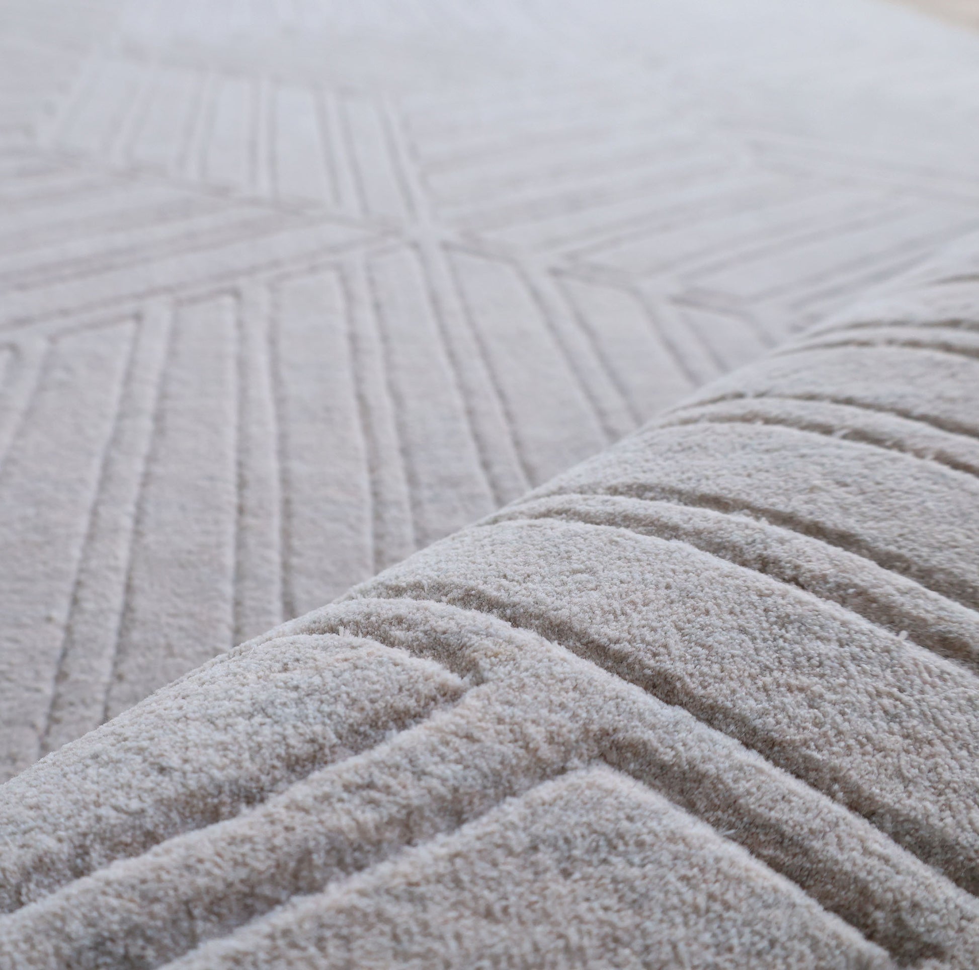 Close-up of the RAMSHA HOME "Home Decor Light Grey Color Handmade Area Rug 300x400 cm - LKH-044," highlighting its handwoven texture and geometric raised line patterns, with a softly blurred background.