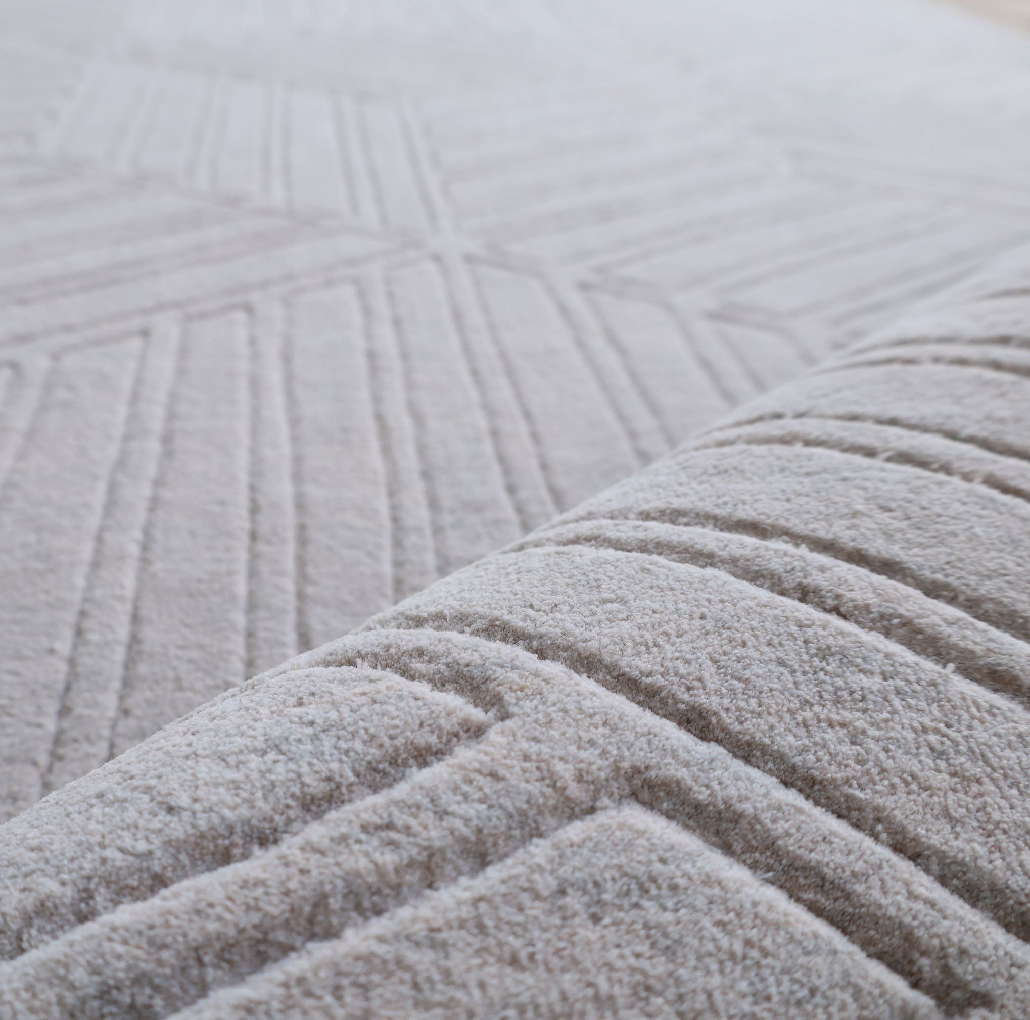 Close-up of the RAMSHA HOME "Home Decor Light Grey Color Handmade Area Rug 300x400 cm - LKH-044," highlighting its handwoven texture and geometric raised line patterns, with a softly blurred background.