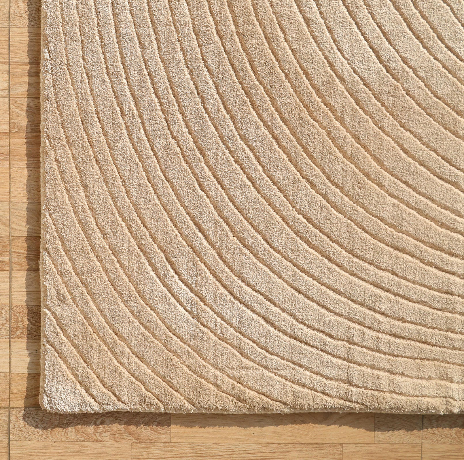 The RAMSHA HOME Handmade Beige Wave Modern Abstract High-Low Area Rug (250x350 cm, LKH-049) features raised curved lines in a high-low texture, shown here on a light wooden floor to highlight its distinctive design and neutral tone.