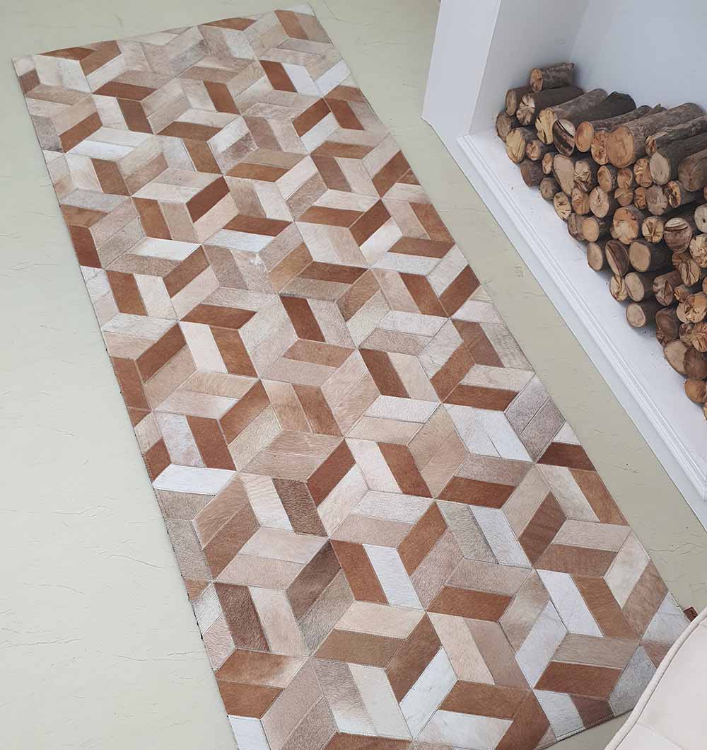The RAMSHA HOME Geometric Cube Pattern Handmade Leather Area Rug LR-012, featuring a 3D cube design in brown, beige, and cream tones, is placed beside a fireplace with neatly stacked firewood.