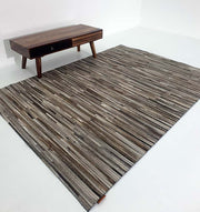 Rectangular leather and wool rug in home decor, functioning as a hard-wearing room foundation with a layered build.