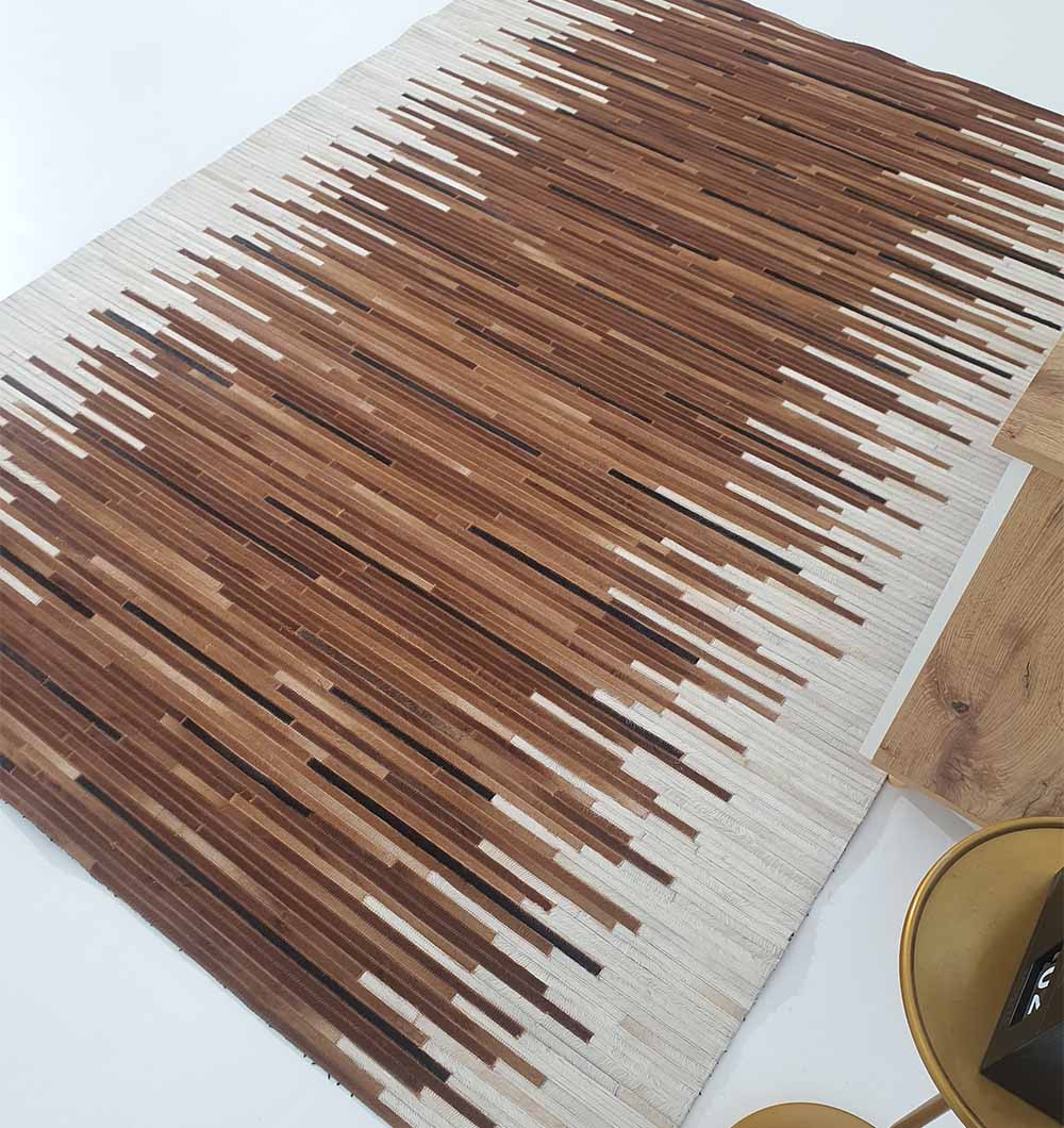 The Handmade Multi-Color Leather and Wool Area Rug LR-014 by RAMSHA HOME features brown and black stripes on white, creating a gradient effect. Ideal near wood or gold tables, this rug adds a modern touch to any white-floored space.