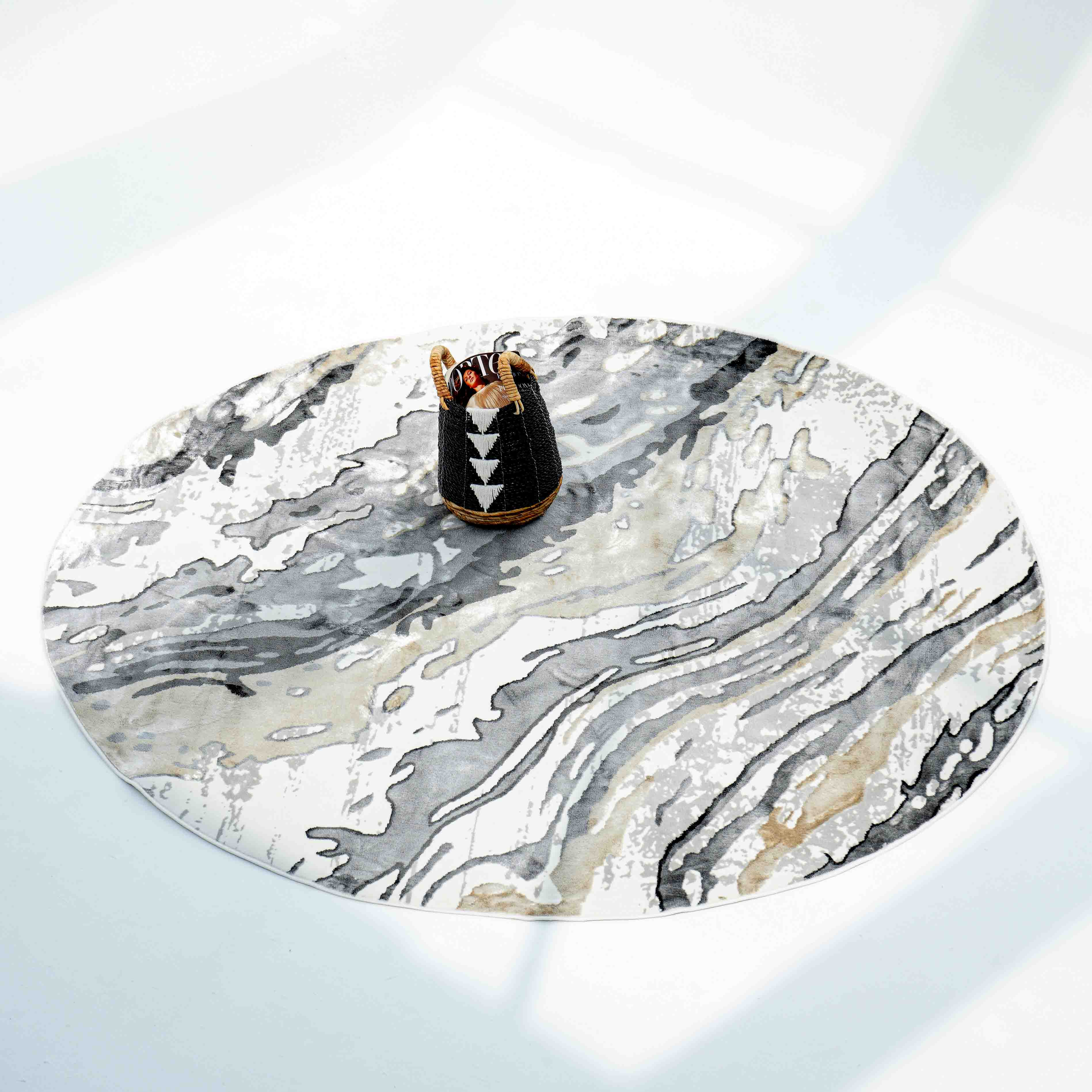 A round marble-patterned table sits on the RAMSHA HOME Shrink Cream ND53K Polyester Decorative Floor Rug. At the center, a small black vase with white geometric designs holds orange decorative sticks.