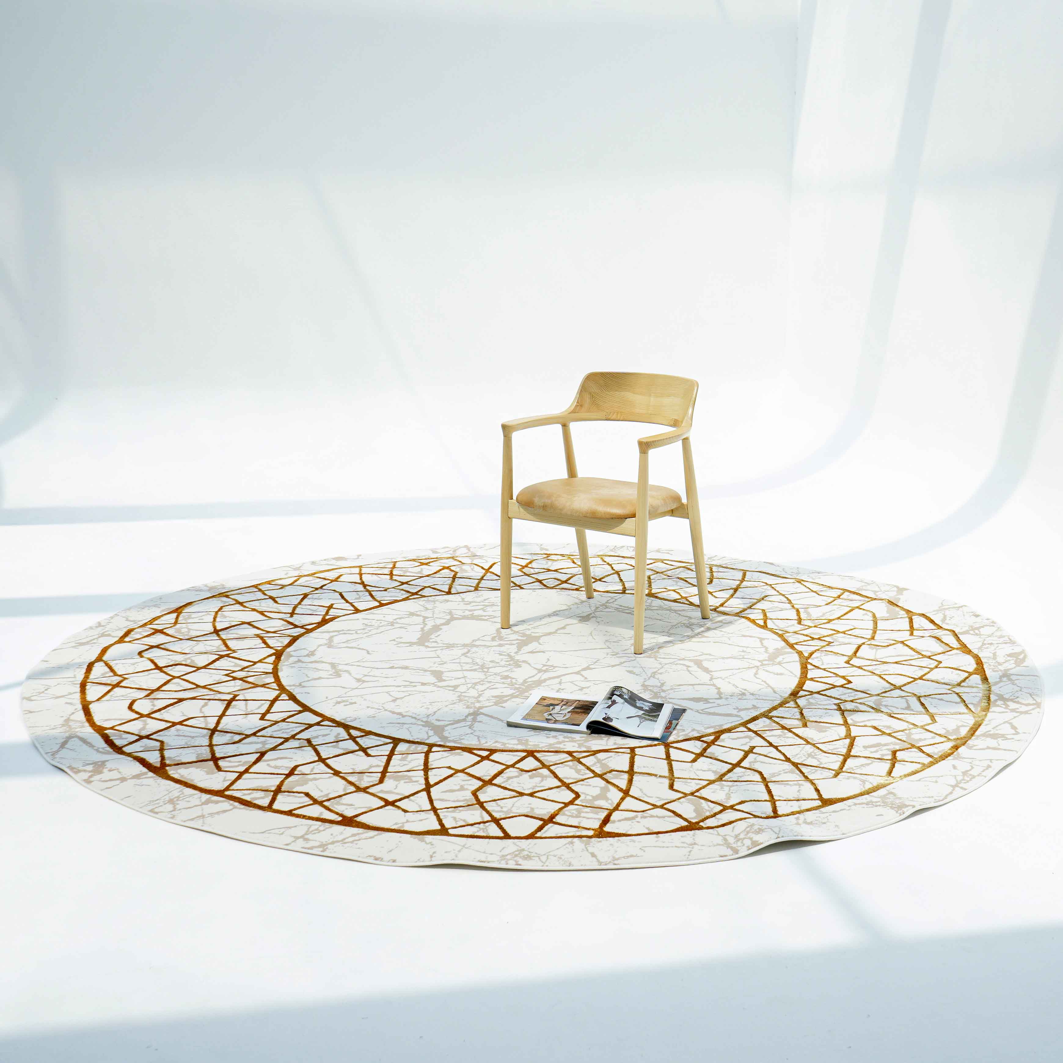 A single light wooden chair sits on the RAMSHA HOME Cream Shrink Cream Colored Geometry Pattern Turkey Rug MZ67C, softly lit with open magazines scattered atop its cream and ivory tones, set against a minimal white background.