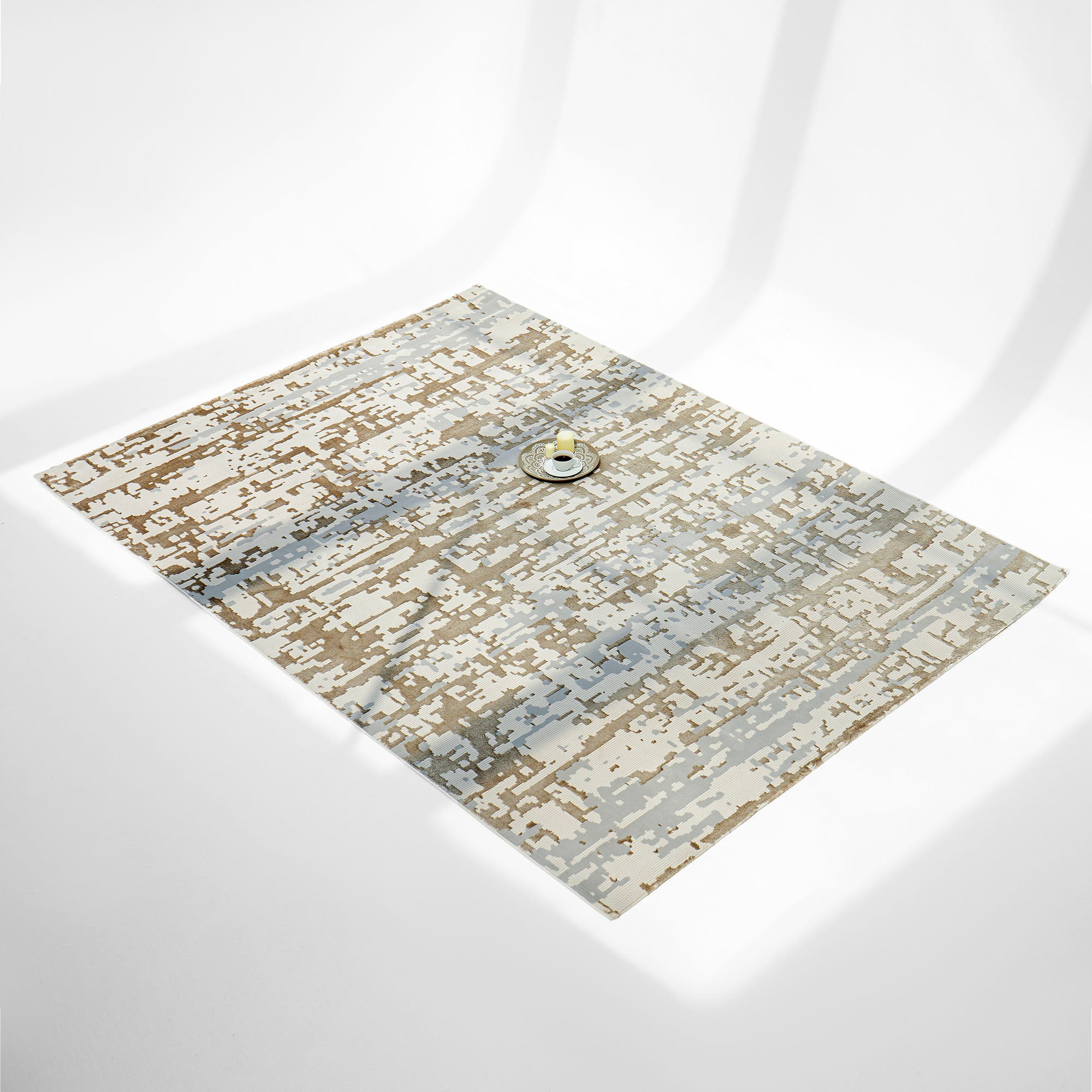 The RAMSHA HOME Stunning Abstract Pattern Machine Made Rug - MZ40K, a rectangular polyester piece with pixelated beige, brown, gray, and cream tones, rests on a white surface with a tray and cup atop its stain-resistant design.