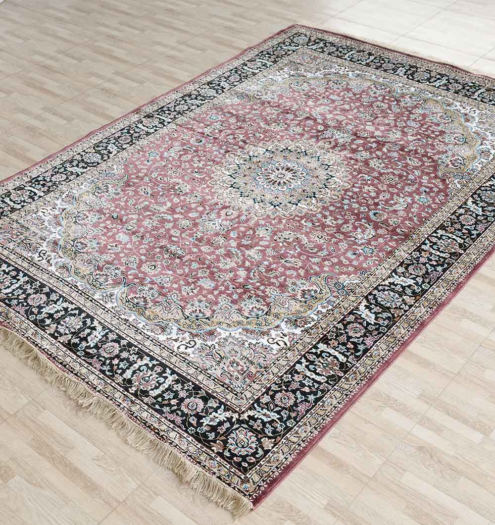 The RAMSHA HOME Persian Floral Medallion Burgundy Rug with Black Border – MMB 04 (150x210 cm) features intricate floral patterns, a central medallion, and fringed edges, and is shown on a light wooden floor.