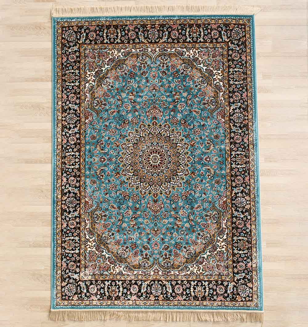 The RAMSHA HOME Persian Floral Medallion Teal Blue Rug (MMB 05, 150x210 cm) features intricate floral and geometric patterns with a teal blue center medallion, black border, and beige and brown accents, shown on a light wood floor.