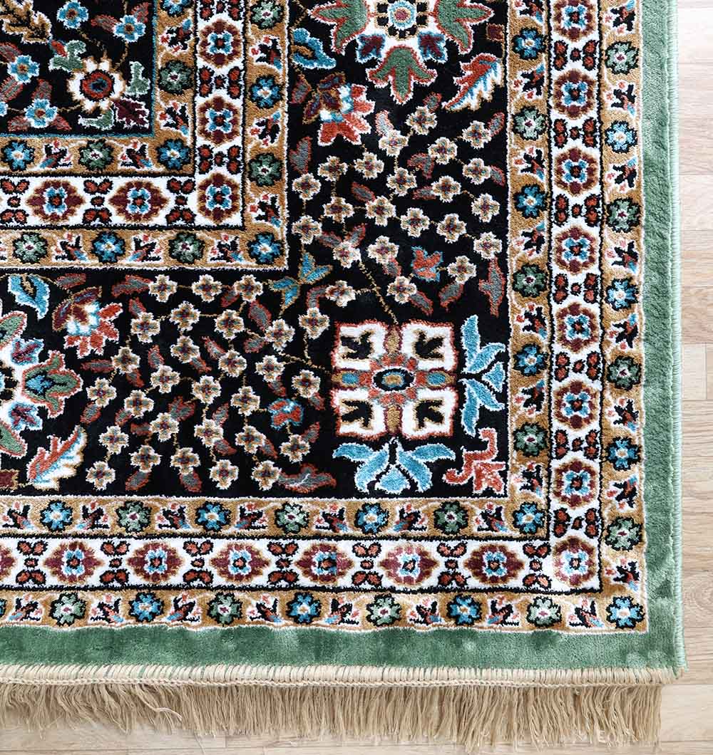A close-up of the RAMSHA HOME Persian Medallion Mint Green & Black Border Rug – MMB 17 (265x365 cm), featuring intricate floral and geometric patterns, a green border, and beige fringe displayed on a light wood floor.
