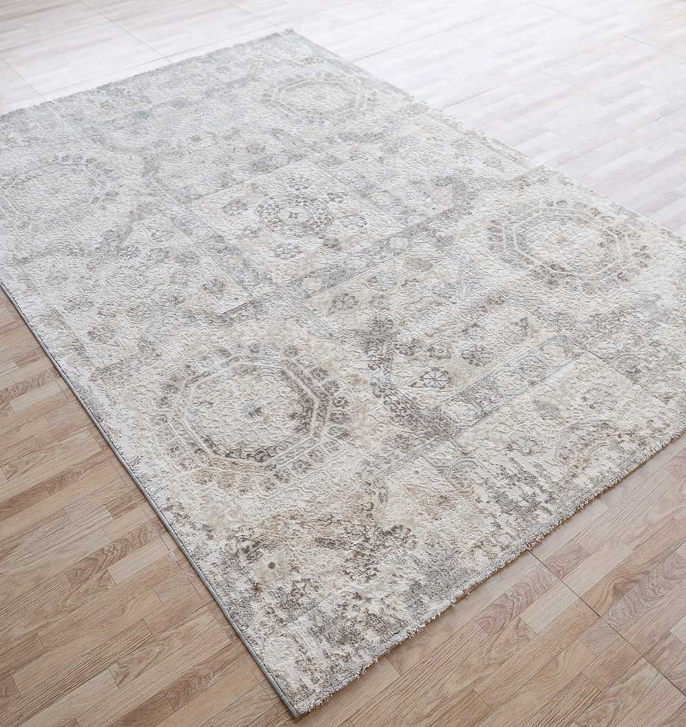 The RAMSHA HOME Modern Multi Abstract Machine-Made Carpet - MMB 79 (180 x 270 cm), featuring subtle geometric and floral patterns, lies on a wooden floor in a bright room.
