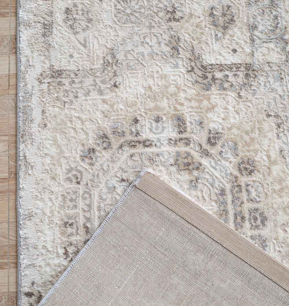 A close-up of RAMSHA HOME’s Modern Multi Abstract Machine-Made Carpet (MMB 79, 180 x 270 cm) on a wooden floor, with one corner flipped to display the plain woven underside.