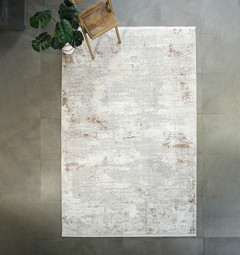 The RAMSHA HOME Cream Gold Machine Made Turkish Rug - MR172 FLORENCE rests on a gray tiled floor, with a wooden chair and potted plant in the top left corner, creating an inviting atmosphere.