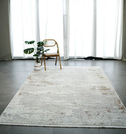 A minimalist room with sheer white curtains, a RAMSHA HOME Cream Gold Machine Made Turkish Rug (MR172 FLORENCE), a wooden chair, and a potted plant on tiled floors. Natural light fills the space.