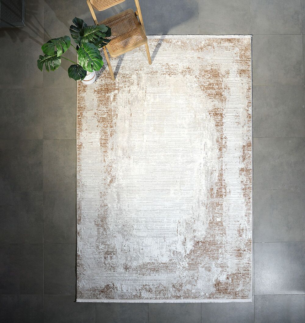 A RAMSHA HOME Machine Made Cream Gold Color Turkish Rug (MR359 FLORENCE) rests on a gray tile floor, with a wooden chair and potted green plant in the top left corner.