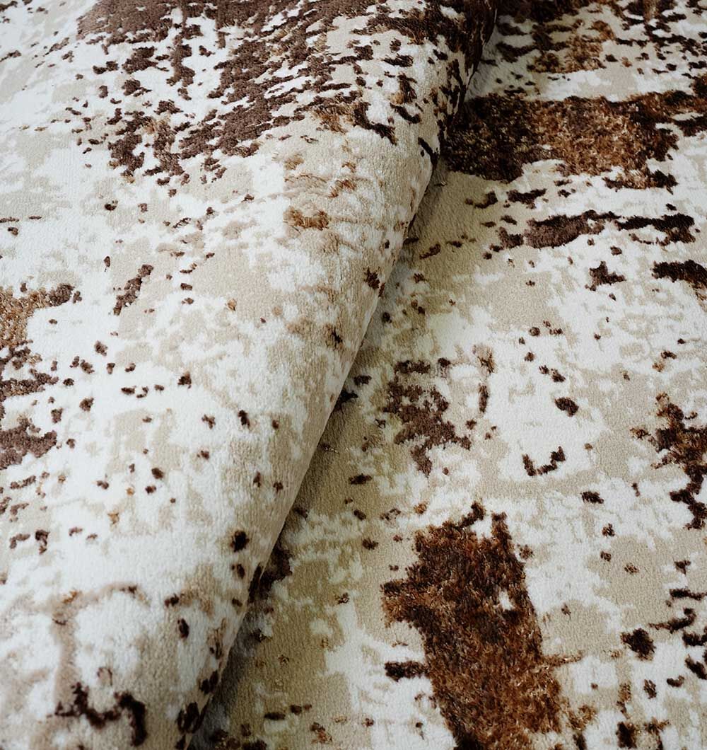 Close-up of the RAMSHA HOME Beige & Dark Brown Turkish Area Rug - N371B MADRID, featuring a modern mottled pattern and plush texture. A folded section highlights the rich color and texture variation of this stylish area rug.