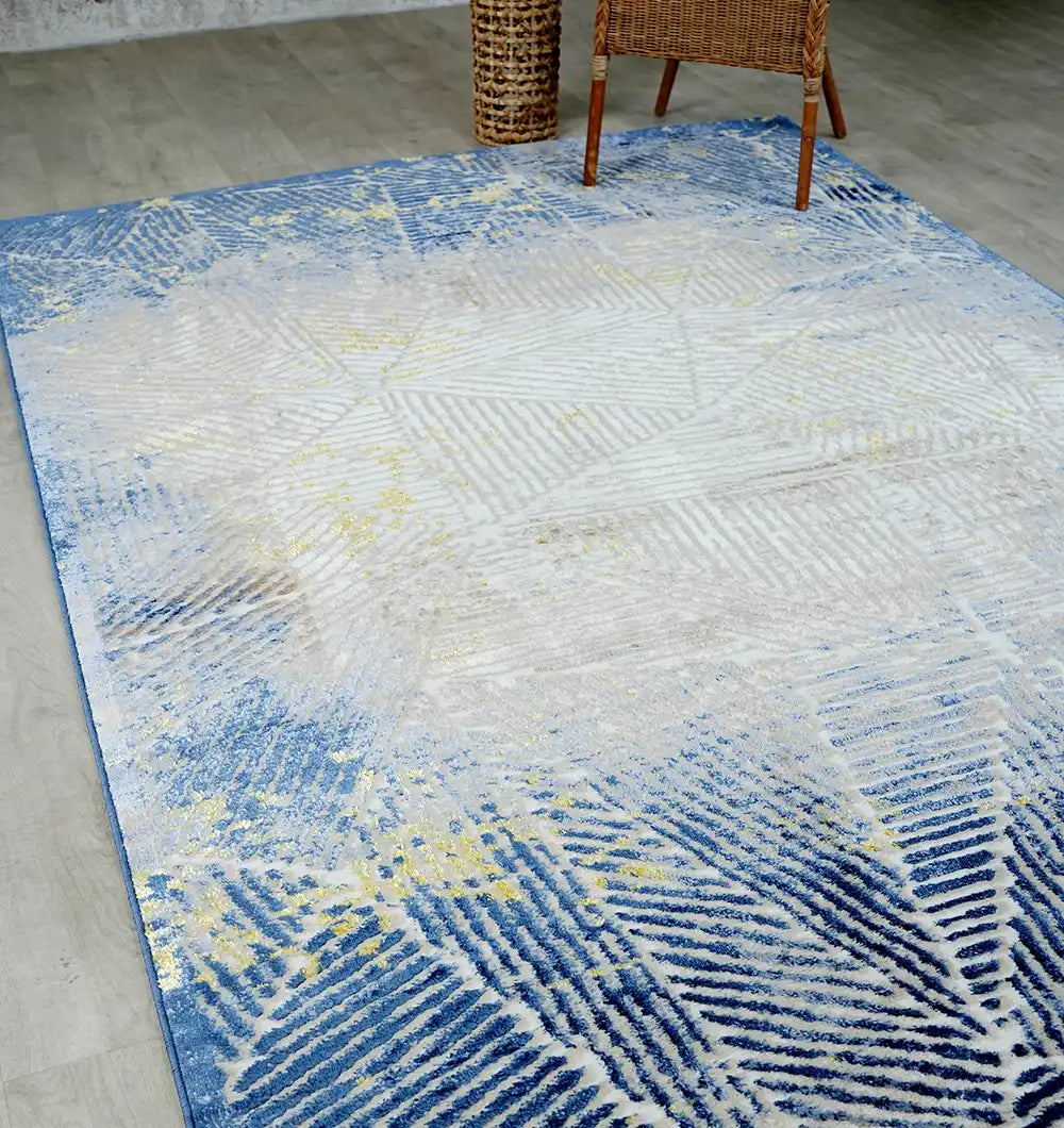 The RAMSHA HOME Abstract Geometric Machine Made Turkish Area Rug - N405A MADRID in denim blue, white, and yellow brightens the light wood floor. A woven chair and basket add warmth to the modern space.