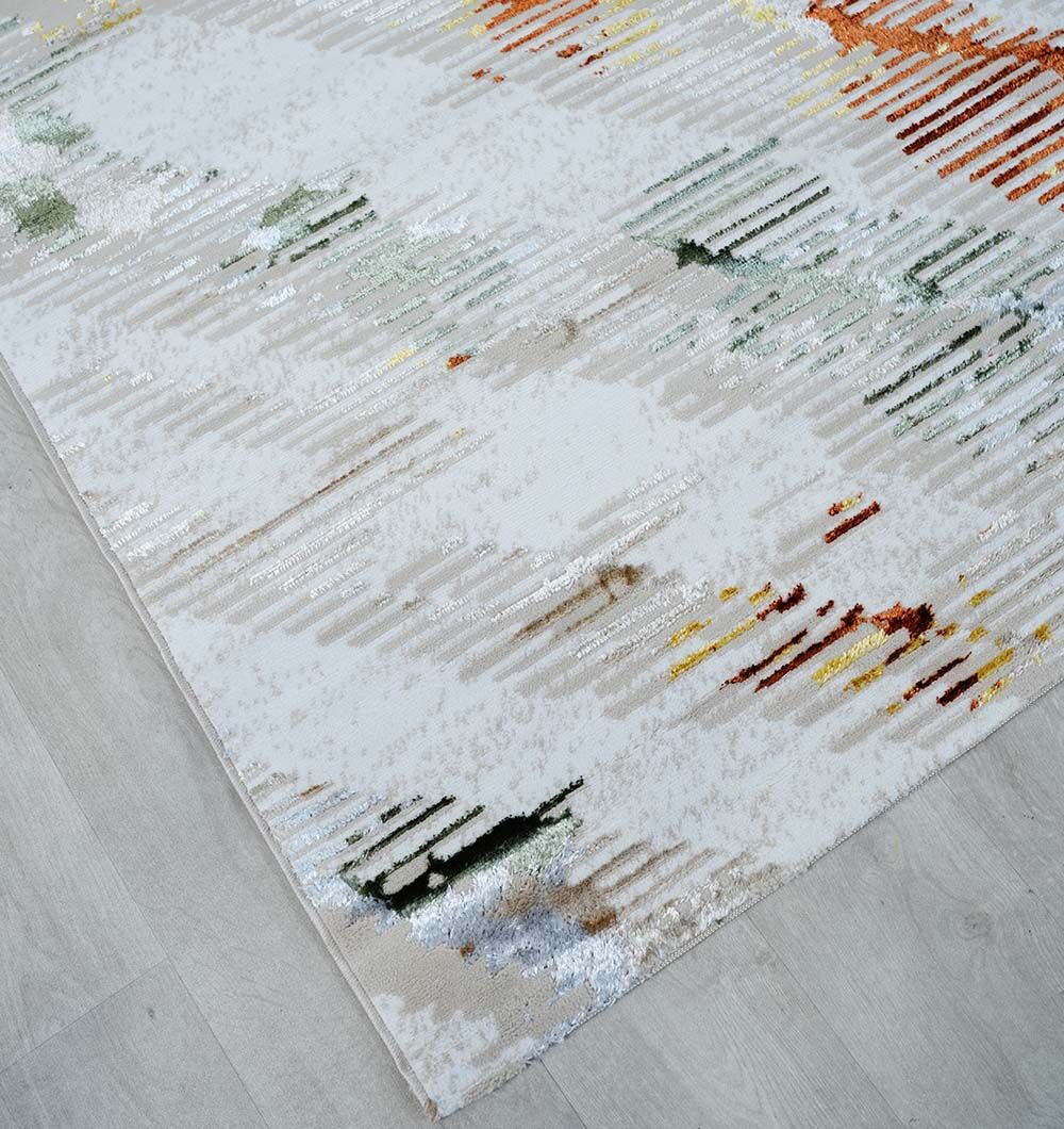 A close-up of the RAMSHA HOME Machine Made Turkish Decor Rug - NK73A MADRID, featuring an abstract pattern in white, beige, green, yellow, and orange, displayed on a light wood floor.