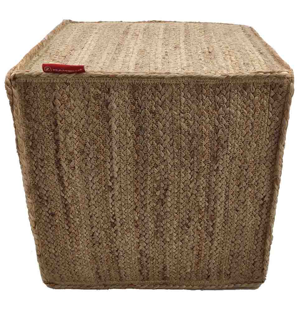 The Jute Pouf Natural Color PF-004 by RAMSHA HOME is a square decorative pouf woven from natural jute with a braided pattern and a small red fabric tag in the top left corner.