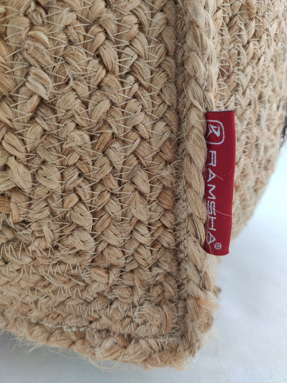 Detailed texture shot of handcrafted jute pouf featuring natural fibers interwoven with sparkling sequins for a refined finish.