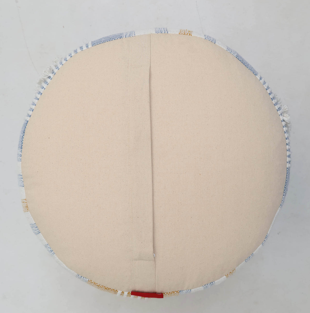 The Boho Modern Round Pouf With Insert PF 109 by RAMSHA HOME features a central seam and is accented with a subtle blue and gold striped trim along the edge. Set against a plain white background, this round beige floor pouf effortlessly blends style and function—making it an ideal decorative accent or a comfortable option for extra seating.