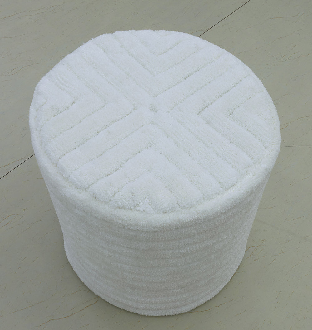 The RAMSHA HOME Luxury Handmade Pouf with Thermocol Bean Bag Insert PF-149 is a round, white, textured ottoman featuring a geometric top pattern, perfect as extra seating for spaces with light-colored tiled floors.