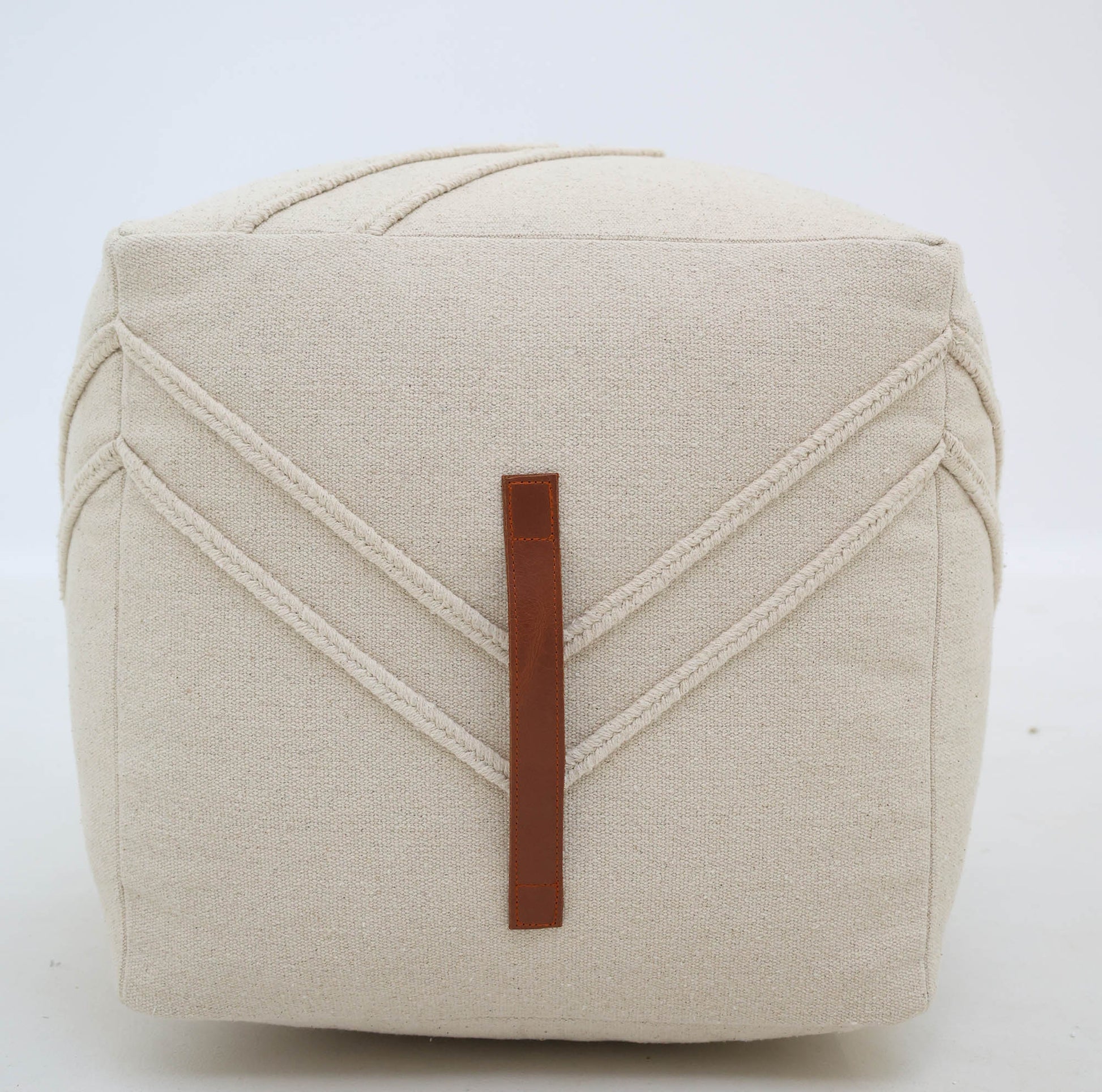 The RAMSHA HOME Ivory Nordic Bliss Cotton Pouf with insert PF 172 is a beige, cube-shaped handmade accent featuring subtle stitched V lines and a brown vertical faux leather strap, shown set against a plain white background.