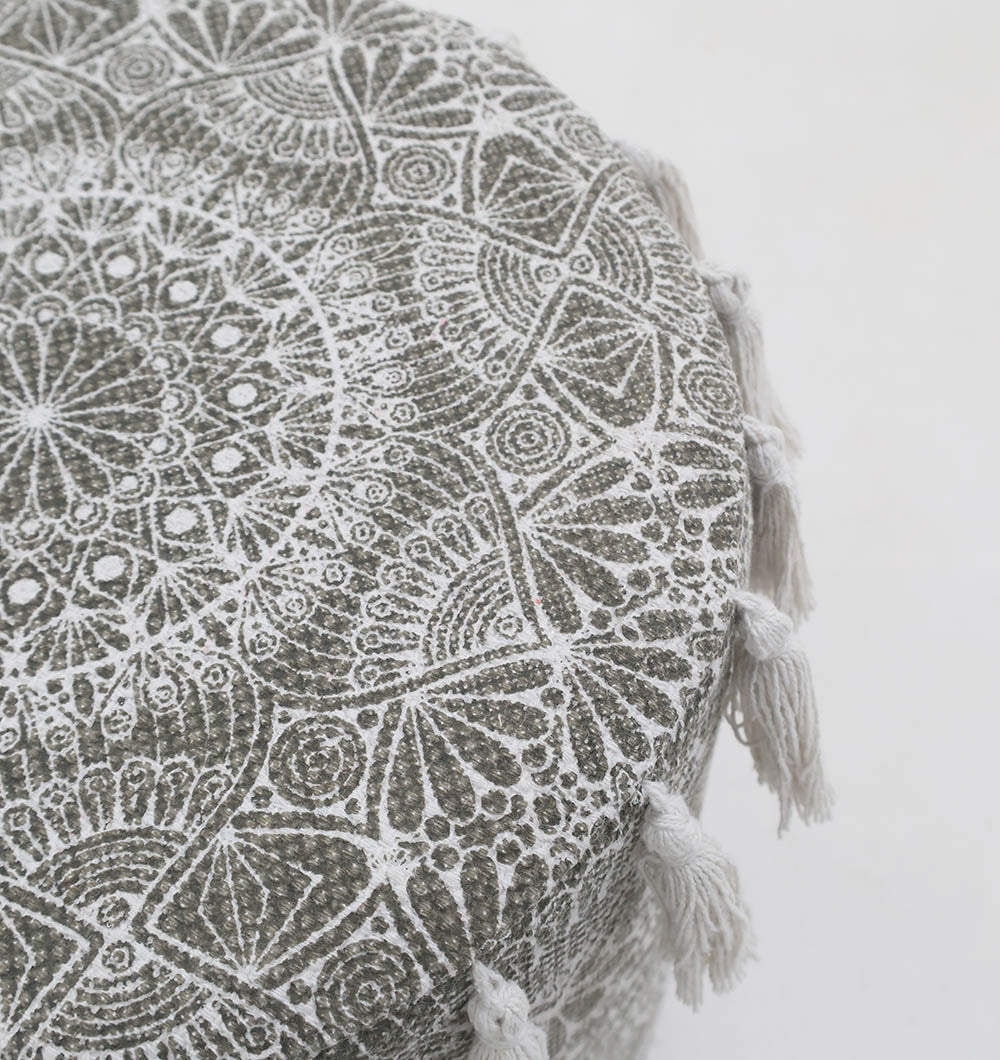 The RAMSHA HOME Stylish cotton printed pouf with decorative tassels PF 174 features an intricate white mandala on gray and white tassels at the edges, adding a chic boho touch to your space.