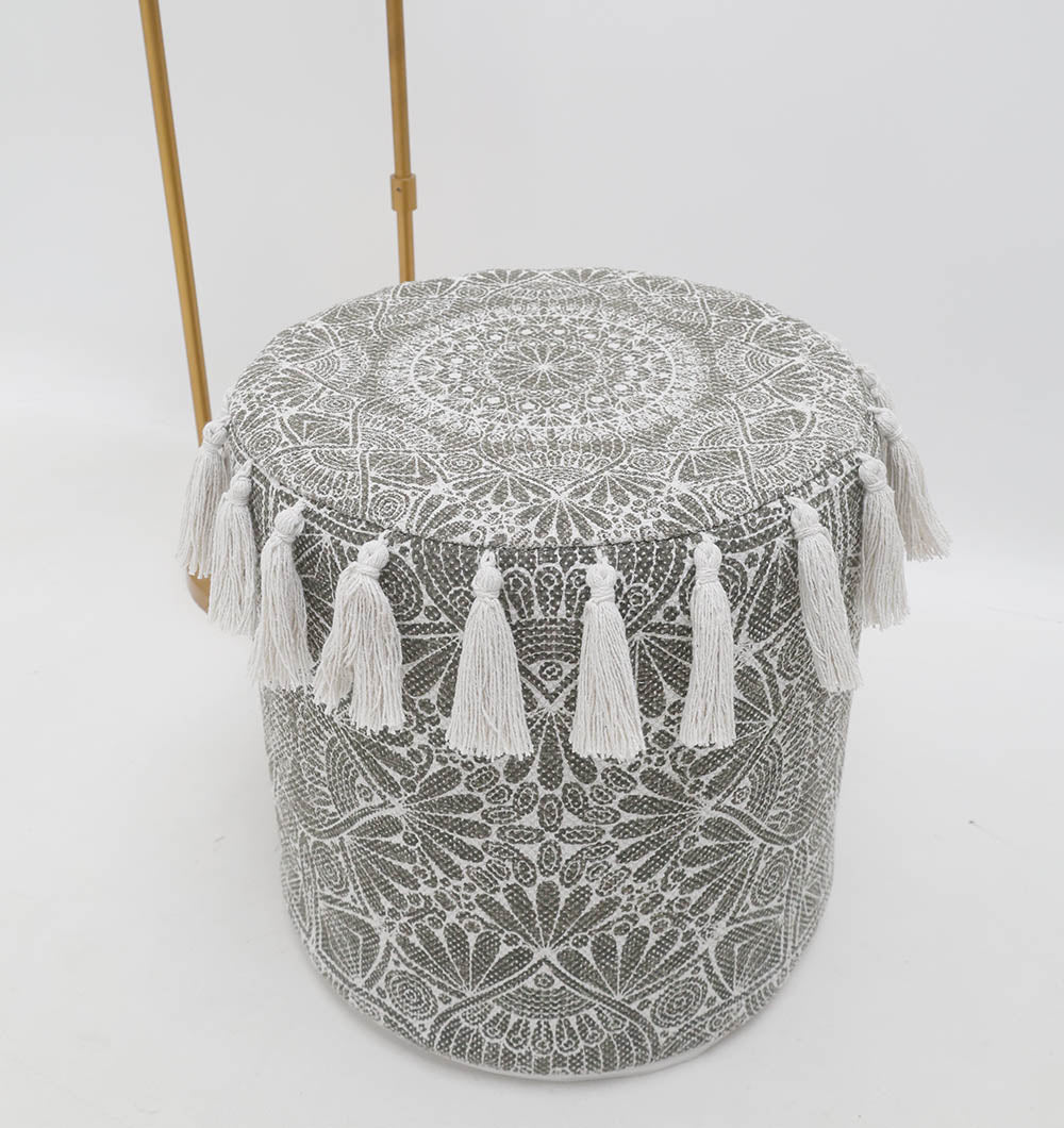 The RAMSHA HOME Stylish cotton printed pouf with decorative tassels PF 174 features intricate gray and white fabric with tasseled trim—an ideal boho accent for any room.