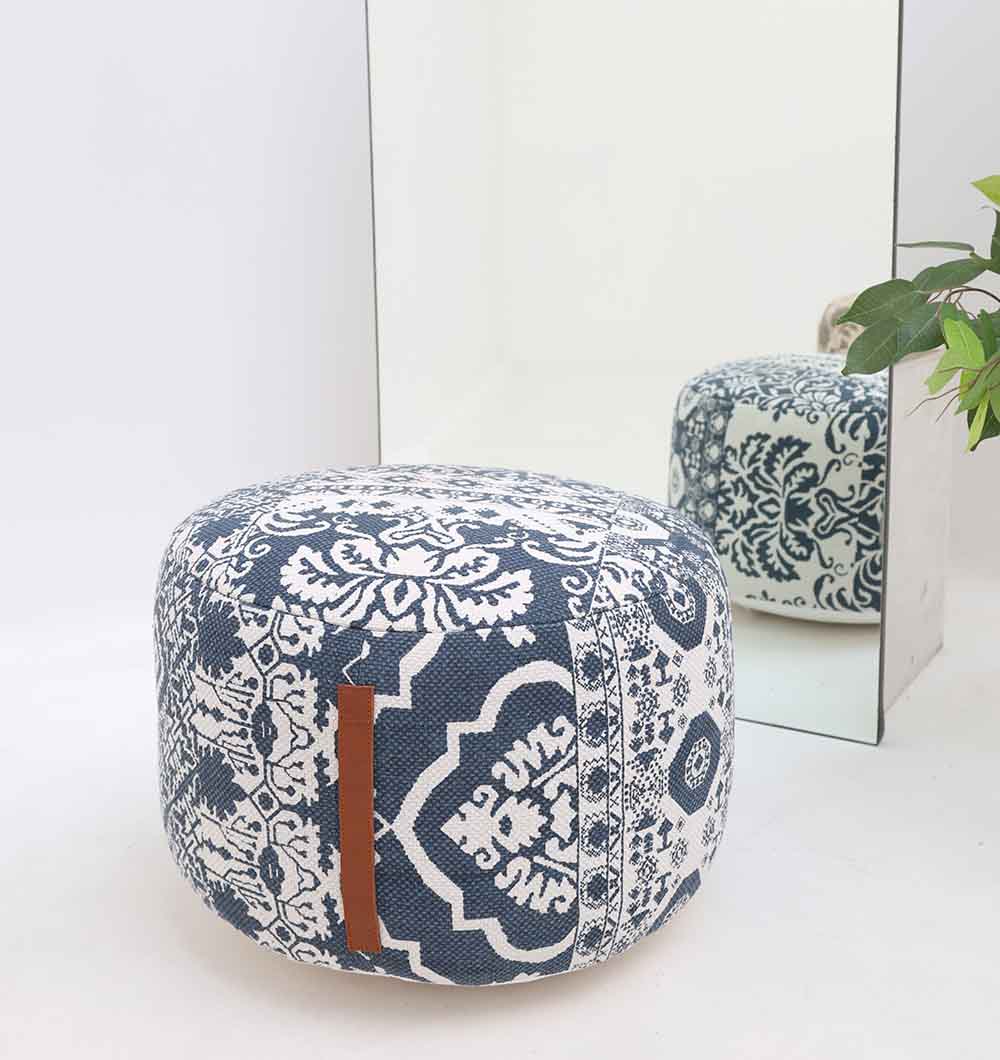 The RAMSHA HOME Boho Printed Round Pouf with Insert PF 176 in blue and white sits in front of a mirror, its chic design reflected. A leafy potted plant nearby completes this perfect home décor accent for any space.