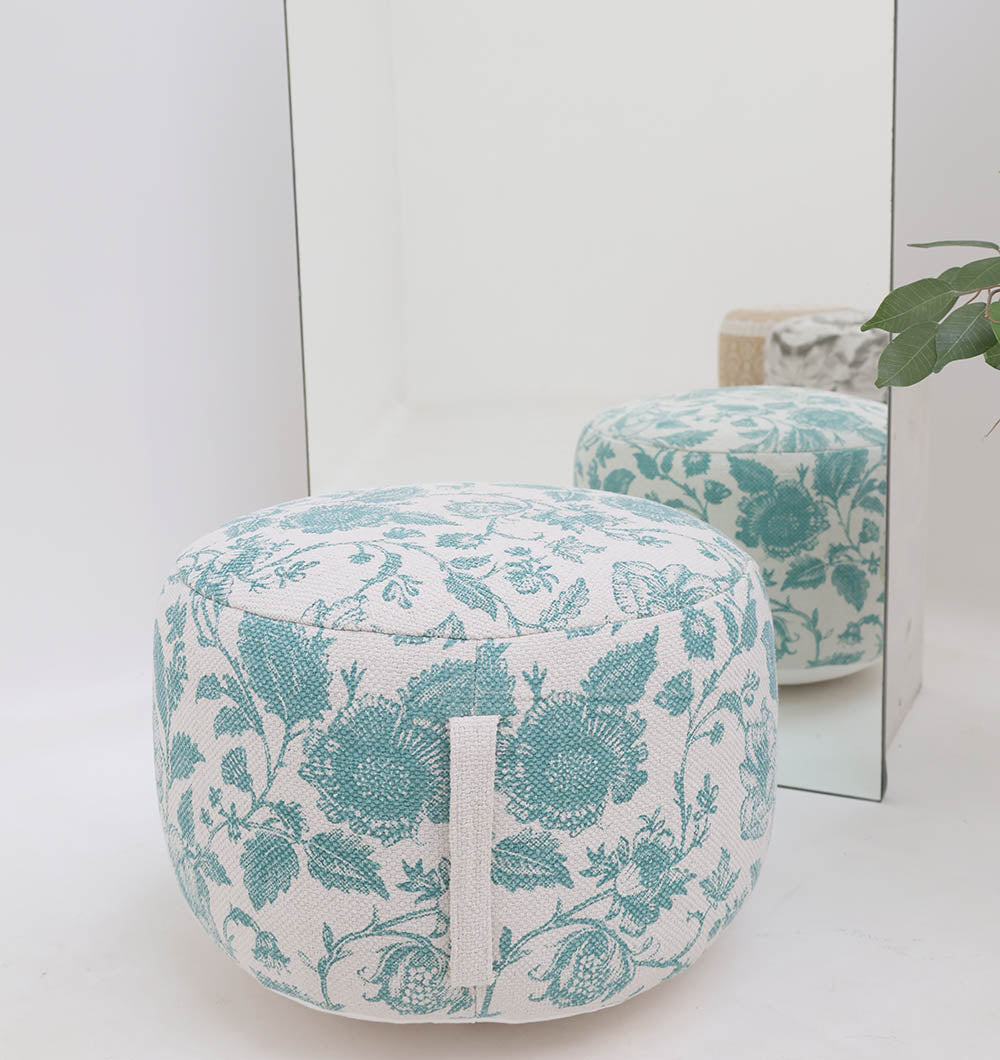 The RAMSHA HOME Round Bohemian Printed Pouf with Comfortable Insert PF 177, featuring a teal pattern, adds decorative seating in front of a mirror. A green plant is partially visible on the right side of the scene.