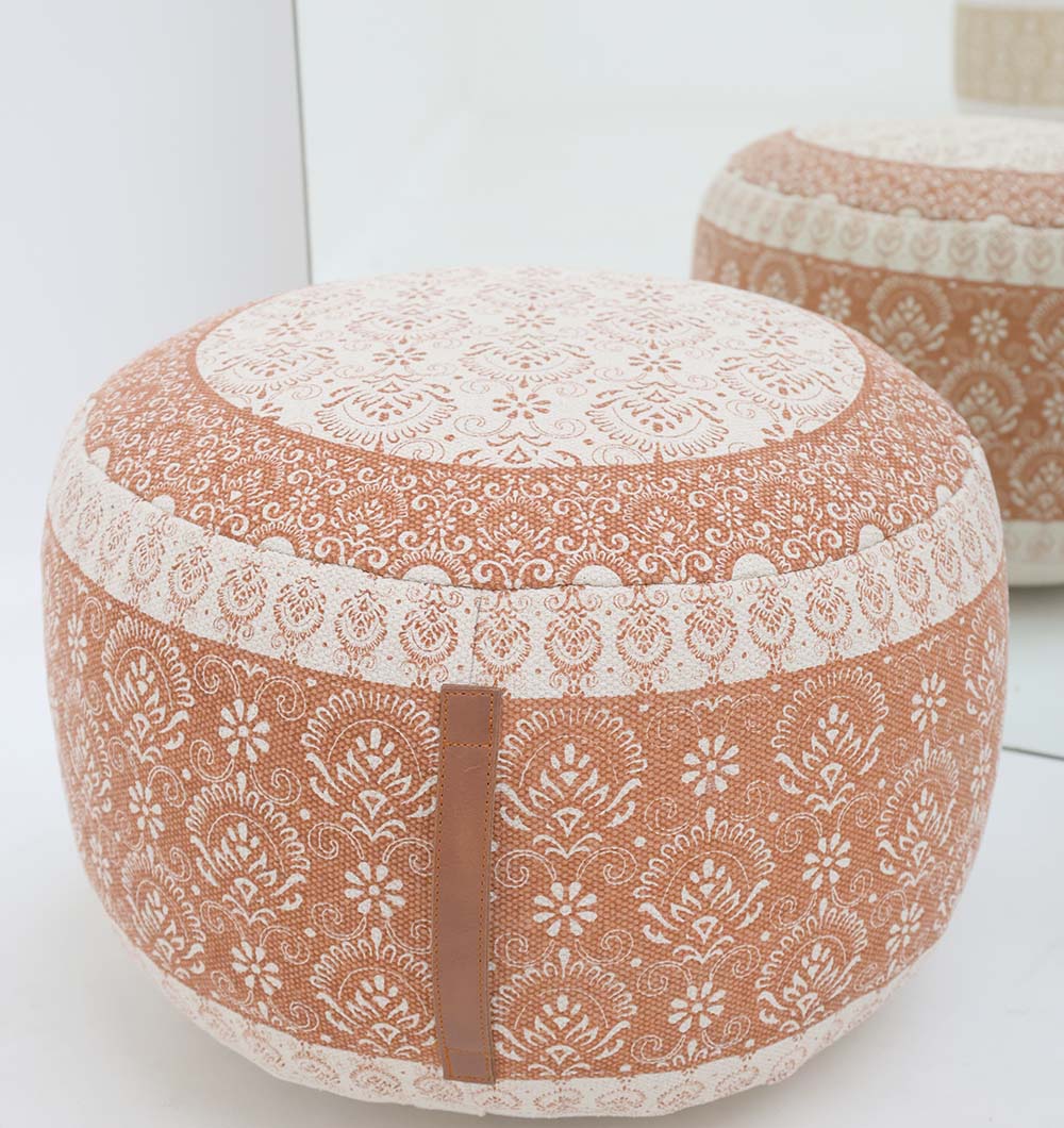 The RAMSHA HOME Round Bohemian Printed Pouf with Comfortable Insert PF 180 features a floral design and lace-like patterns, adding decorative seating on a white floor, its charm reflected in the mirror behind.