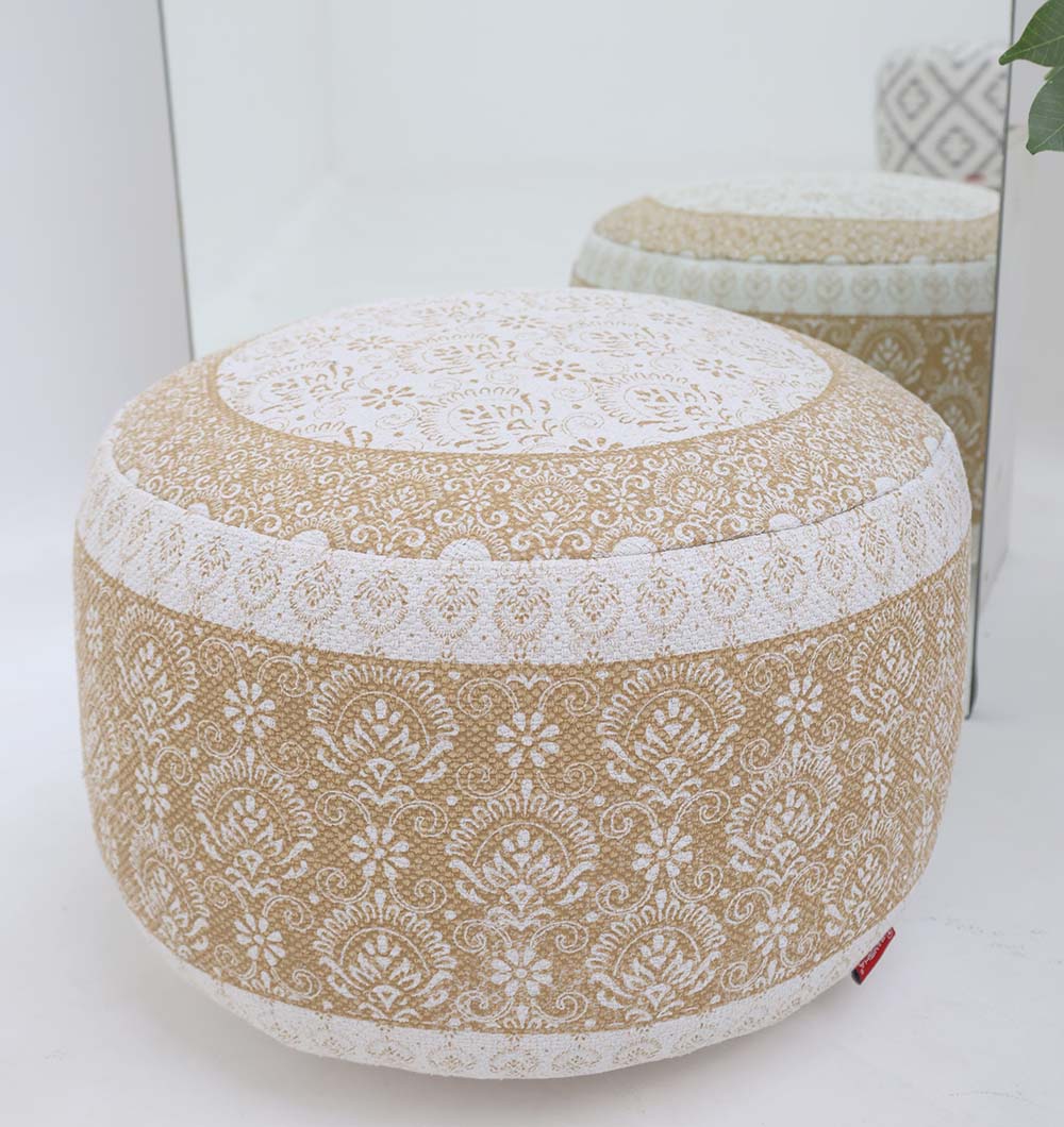 The RAMSHA HOME Round Bohemian Printed Pouf with Comfortable Insert PF 180, featuring intricate floral patterns, sits stylishly in front of a mirror with a green plant visible in the background.