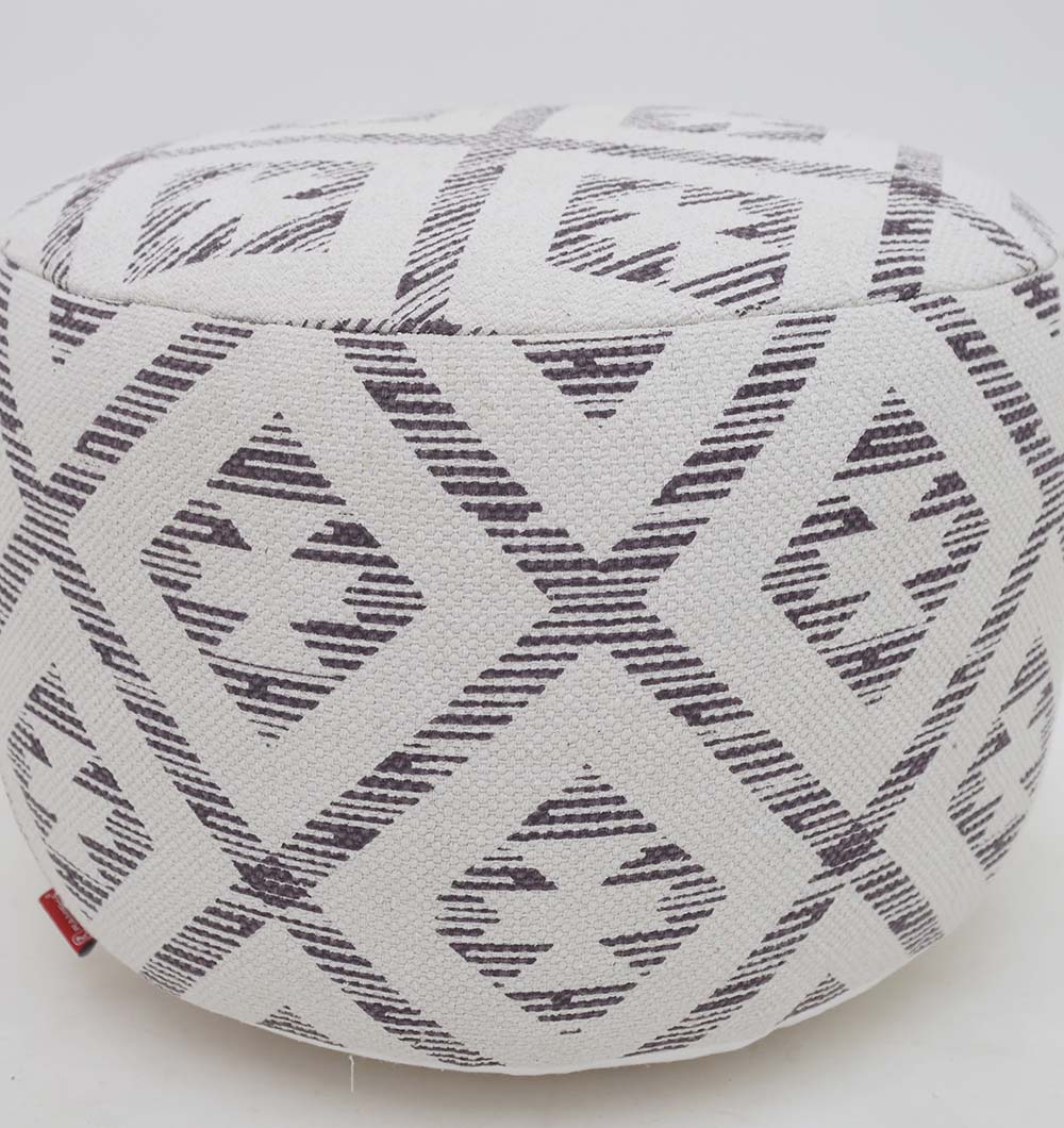 The RAMSHA HOME White Color Modern Diamond Pattern Round Pouf with Insert PF 185 features a geometric diamond and stripe print on white fabric, plus a thermocol insert for a lightweight, sturdy ottoman perfect for versatile home use.