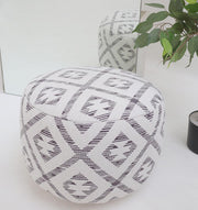 The RAMSHA HOME White Color Modern Diamond Pattern Round Pouf with Insert PF 185 sits on a white floor near a mirror and a potted plant, adding stylish flair as both the pouf and its modern pattern are reflected in the mirror.
