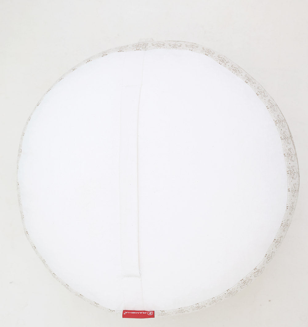 The RAMSHA HOME Modern Printed Round Pouf with Insert PF 186 features a subtle patterned edge, a central horizontal fabric handle, and a thermocol insert for added comfort, all resting on a light-colored surface.
