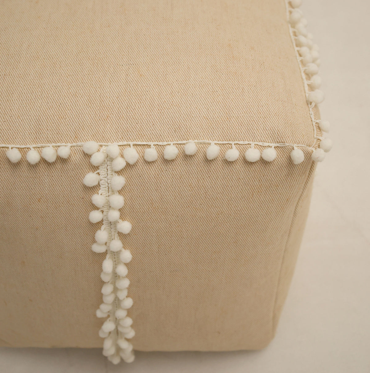 A close-up of the Square Jute Floor Pouf with Fringes PF 193 by RAMSHA HOME, featuring textured natural jute and stylish fringe detailing along the edges, shown on a light background—an inviting accent piece perfect for any room.