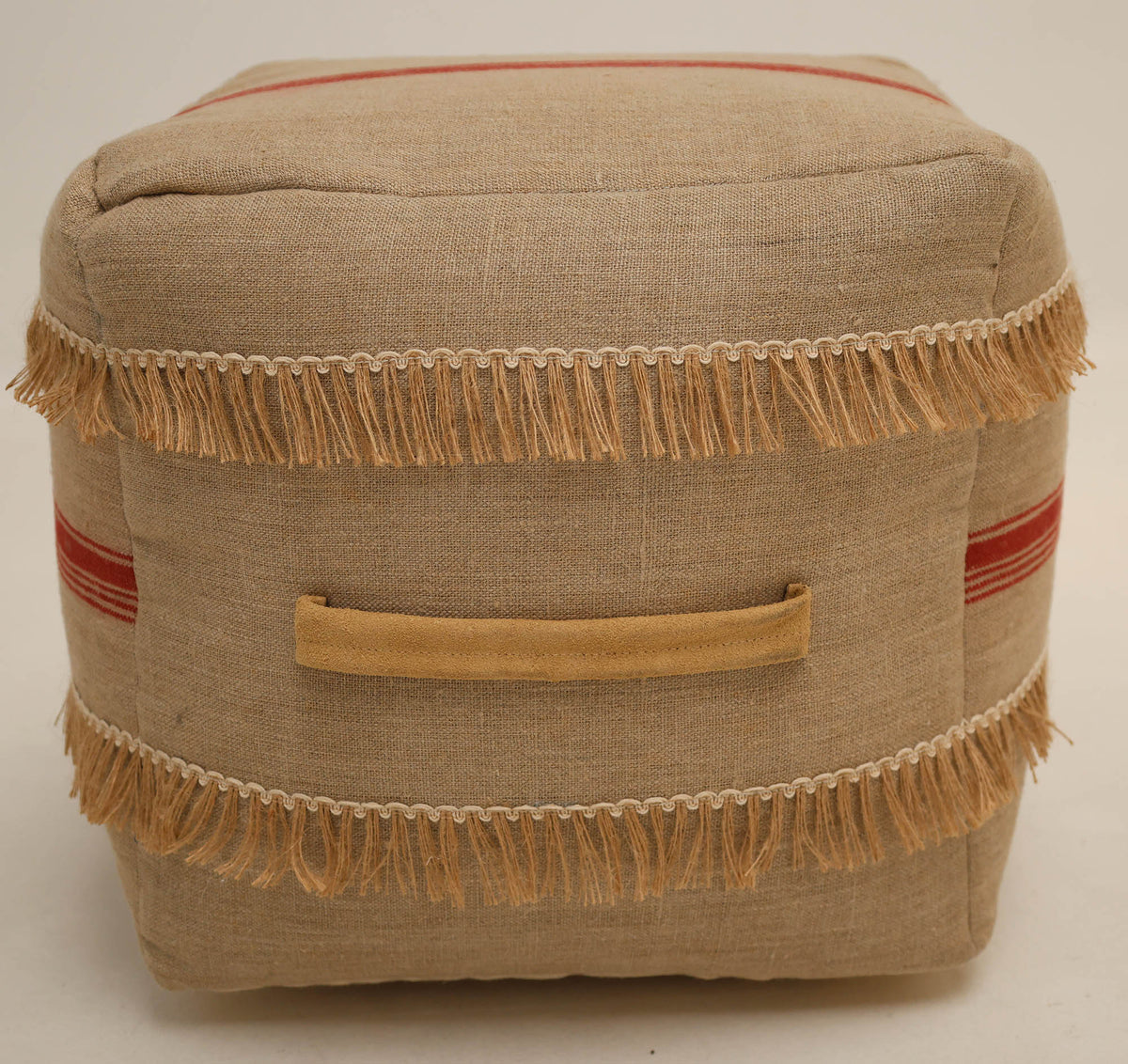 Introducing the Square Jute Floor Pouf with Fringes PF 192 by RAMSHA HOME—a square beige ottoman crafted from fabric with tan fringe detailing, two horizontal red stripes, and a convenient tan fabric handle on the side. Its textured, rustic look makes it an ideal accent piece to pair stylishly with other décor items such as round floor poufs or jute poufs.