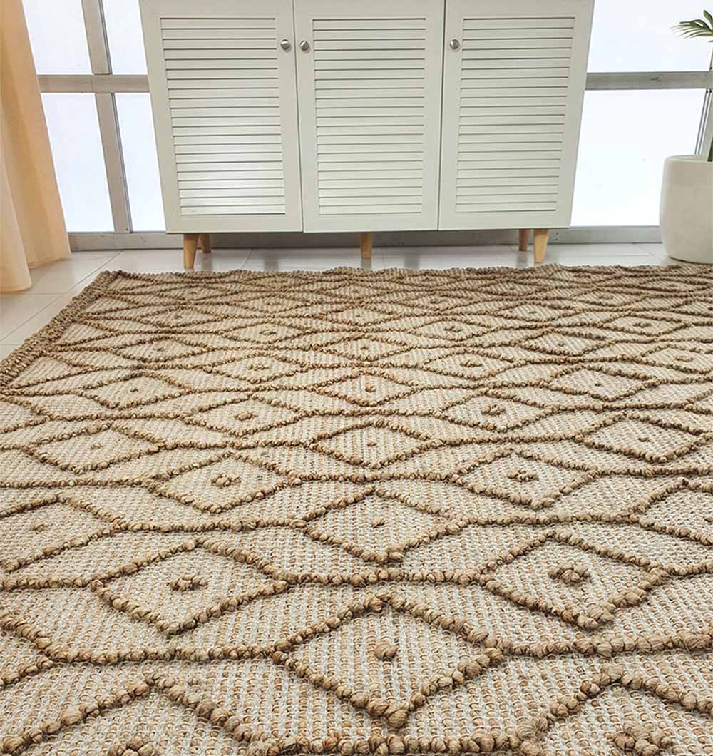 The RAMSHA HOME Brown Rectangle Area Rug and Carpet for Stylish Living Room SR-004 features a geometric diamond pattern and lies in front of a white cabinet with shutter-style doors; a potted plant sits nearby, adding charm to the space.