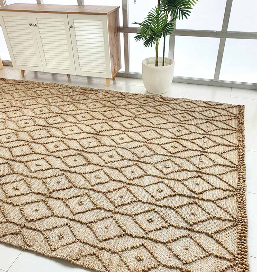 The RAMSHA HOME Brown Rectangle Area Rug and Carpet for Stylish Living Room SR-004 adds a geometric diamond pattern to the tiled floor, with a white slatted cabinet and potted plant by the windows showcasing its durability.